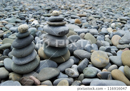 Towers made of pebbles. Two Zen towers on a rocky beach. 116916047