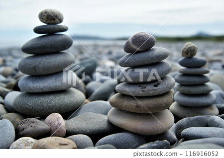 Towers made of pebbles. Three Zen towers on a rocky beach. Towers made of pebbles. Three Zen towers on a rocky beach. 116916052