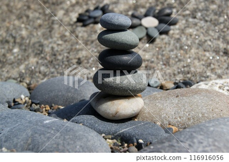 The subject is in focus, the background is blurred. Zen pyramid on rocks. 116916056