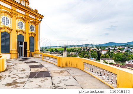A scenic view from the terrace of Melk Abbey with the valley spread out below under a cloudy sky, capturing the blend of history and nature. A scenic view from the terrace of Melk Abbey with the valley spread out below under a cloudy sky, capturing the blend of history and nature. 116916123