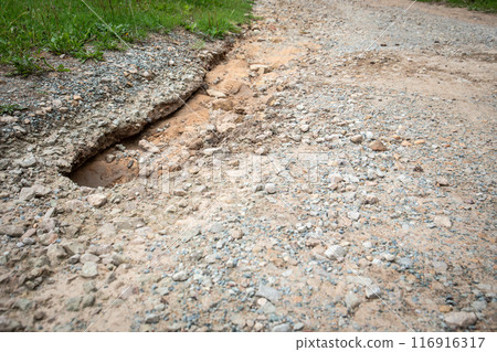 Washed out pothole on the road, deterioration of infrastructure 116916317