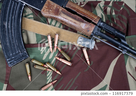 AK assault rifle on camo uniform background AK assault rifle on camo uniform background 116917379