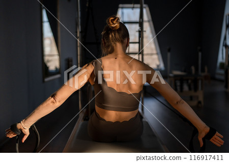 Modern Pilates studio with bright, spacious windows for exercise and wellbeing 116917411