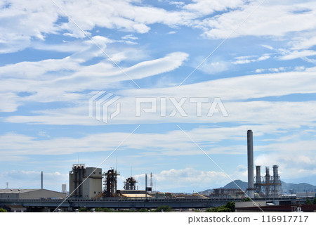 White clouds and chimneys floating above an industrial park White clouds and chimneys floating above an industrial park 116917717