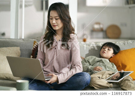 young asian mother with child working at home young asian mother with child working at home 116917873