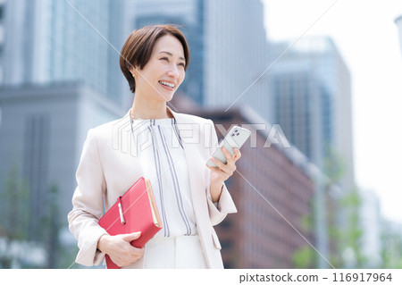 Middle-aged business woman working in an office district 116917964