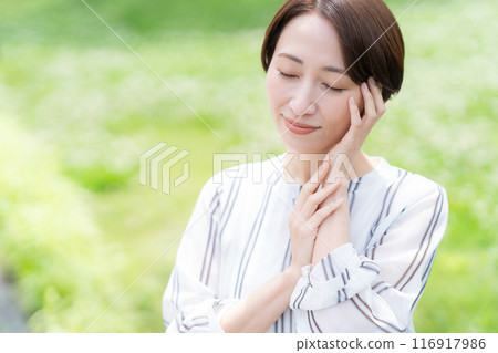 A middle-aged businesswoman doing skin care in an office district A middle-aged businesswoman doing skin care in an office district 116917986