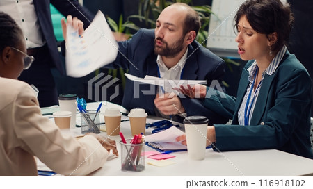 Frustrated business team working under pressure to meet project deadlines, being stressed to finish all important tasks and accomplish the organization goals. Strained corporation meeting. Camera A. Frustrated business team working under pressure to meet project deadlines, being stressed to finish all important tasks and accomplish the organization goals. Strained corporation meeting. Camera A. 116918102