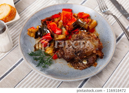 Baked pork with side dish of sauteed veggies on plate Baked pork with side dish of sauteed veggies on plate 116918472