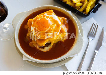 Francesinha served in bowl with beer sauce and fried egg Francesinha served in bowl with beer sauce and fried egg 116918486