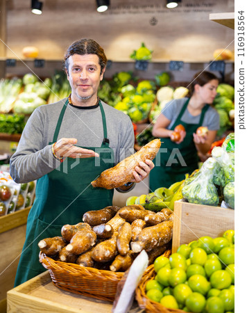 Adult man selling cassava in shop 116918564