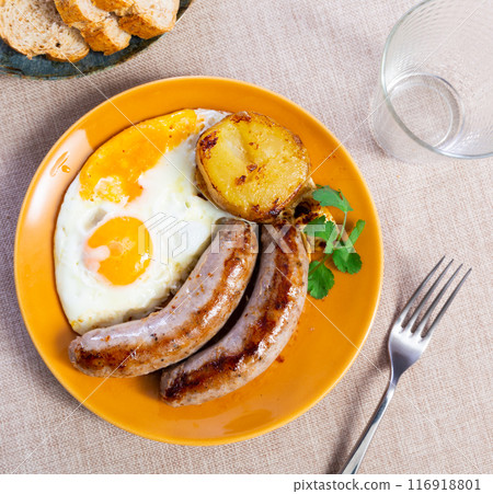 Dinner of scrambled eggs with sausages and potatoes 116918801