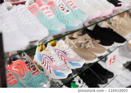 Showcase with models of sneakers in shoe store 116918805