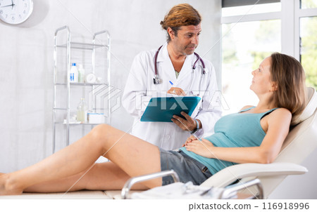 Adult male doctor signing contract with female patient 116918996
