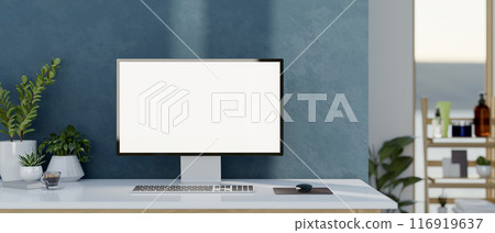 A PC computer with a white-screen mockup on a white table against the blue wall in a modern room. 116919637