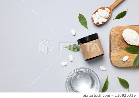 Collagen in powder and tablets with a wooden spoon Collagen in powder and tablets with a wooden spoon 116920339