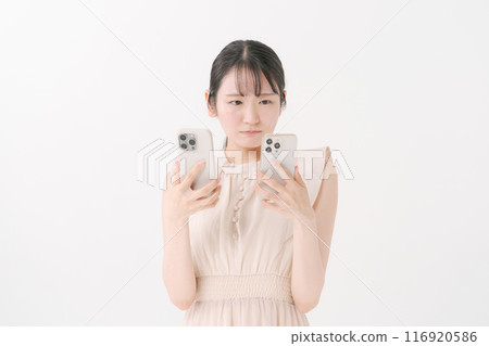 有兩部智慧型手機的年輕女子 有兩部智慧型手機的年輕女子 116920586