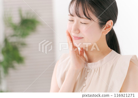 A woman in her 20s touching her cheek A woman in her 20s touching her cheek 116921271