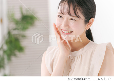 一個 20 多歲的女人摸著臉頰 116921272