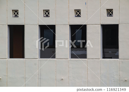 Window on concrete wall outside building 116921349