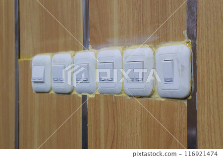 row of wooden wall light switches 116921474