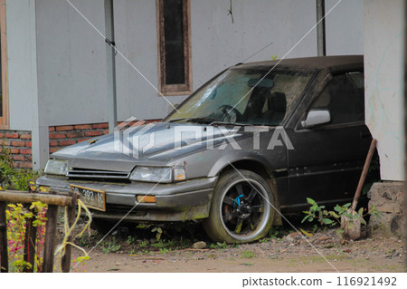 Selective focus of an abandoned rusty damaged car in gray color 116921492