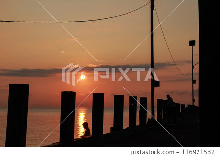 Bright orange sunrise with silhouette of power lines with the Sun 116921532