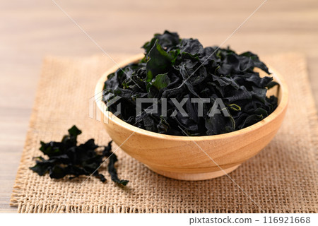Dried Wakame seaweed or sea mustard in wooden bowl Dried Wakame seaweed or sea mustard in wooden bowl 116921668