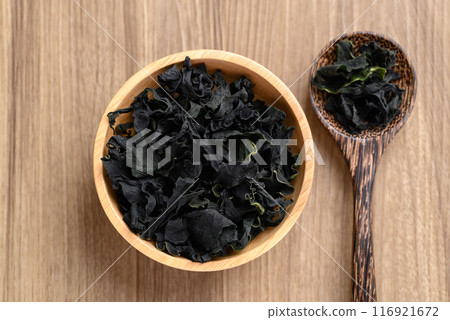 Dried Wakame seaweed or sea mustard in bowl and spoon on wooden background, Table top view 116921672