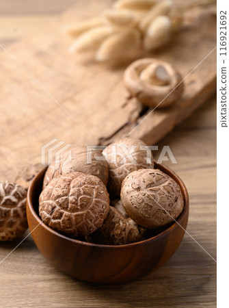 Fresh shiitake mushroom in bowl on wooden background, edible mushroom Fresh shiitake mushroom in bowl on wooden background, edible mushroom 116921692