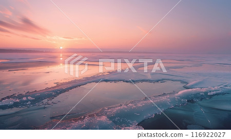 Dawn breaks over the frozen lake, its ice reflecting soft pinks and oranges, ushering in a peaceful new day. Dawn breaks over the frozen lake, its ice reflecting soft pinks and oranges, ushering in a peaceful new day. 116922027