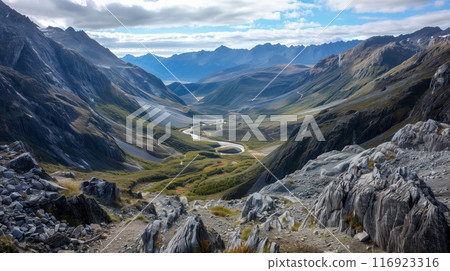 A deep valley nestled between rugged ranges, with a winding river showcasing its serene beauty. 116923316