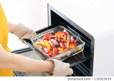 Putting grilled spare ribs and vegetables into the oven Putting grilled spare ribs and vegetables into the oven 116923614