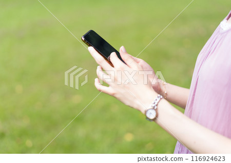 Woman operating a smartphone Woman operating a smartphone 116924623