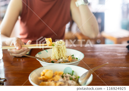 Woman hands holding delicious egg noodle with chopsticks 116924925