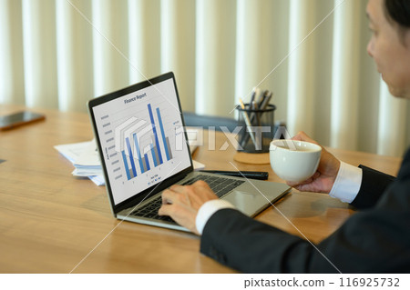 Senior businessman investor sitting at desk and reviewing a financial report on laptop screen 116925732