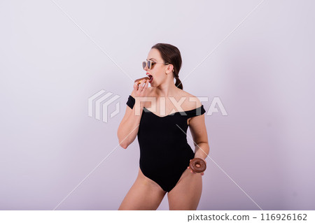 Plus size seductive model female, fashionable blonde in black bodysuit with donut 116926162