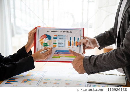 Business professionals discussing project charts and graphs during meeting, focusing on chart with company project details, teamwork, collaboration, and data analysis concepts 116926188