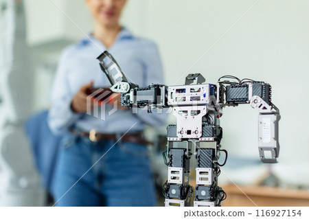 Teacher showing kids how small robot working. Children learning robotics, programming and engineering in Elementary school. Teacher showing kids how small robot working. Children learning robotics, programming and engineering in Elementary school. 116927154