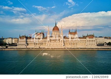 Hungarian Parliament with river Danube, front view. Famous landmark in Budapest. Beautiful architecture with historical building Hungarian Parliament with river Danube, front view. Famous landmark in Budapest. Beautiful architecture with historical building 116928949