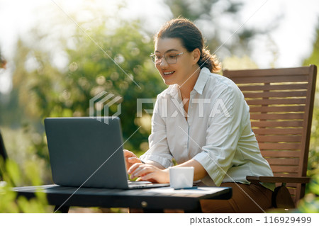 woman working on laptop in summer morning woman working on laptop in summer morning 116929499