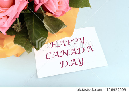 Canadian Independence Day celebration. Words Happy Canada Day on a white business card on a blue background in a composition with a bouquet of flowers Canadian Independence Day celebration. Words Happy Canada Day on a white business card on a blue background in a composition with a bouquet of flowers 116929609