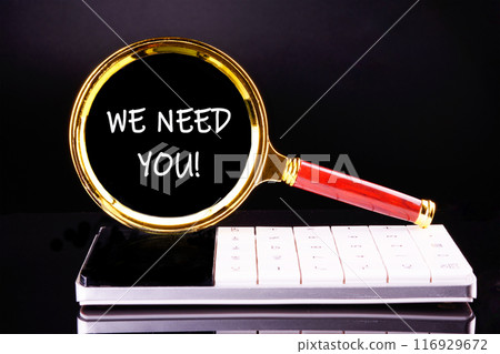 Text WE NEED YOU through a magnifying glass on a calculator on a black background 116929672