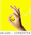 Finger OK symbol and smiley face on a yellow background 116929754