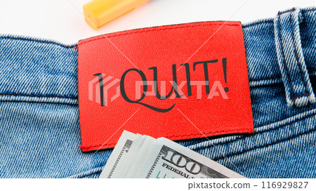 Business text. I Quit word on the red leather label of jeans on a white background in a composition with American dollars 116929827