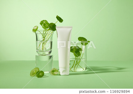 A white sample tube for advertising cosmetic products, which extracted from centella asiatica. Green background photo was shot from frontal, blank space for promotional 116929894