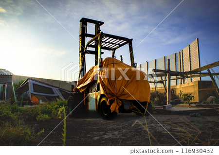 A forklift abandoned and no longer in use in a port town A forklift abandoned and no longer in use in a port town 116930432