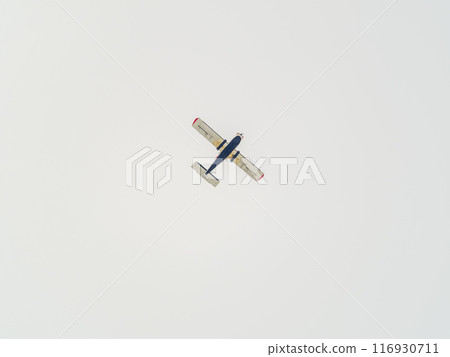 Small ultralight airplane with overhead wing and single propeller flying in sunset sky. Small ultralight airplane with overhead wing and single propeller flying in sunset sky. 116930711
