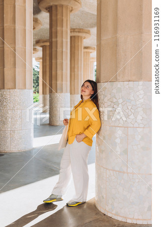 Beautiful female in Gaudi garden, Spain, Barcelona. Young traveling woman posing outdoors. Concept of travel, tourism and vacation in city. Hypostyle hall Beautiful female in Gaudi garden, Spain, Barcelona. Young traveling woman posing outdoors. Concept of travel, tourism and vacation in city. Hypostyle hall 116931169