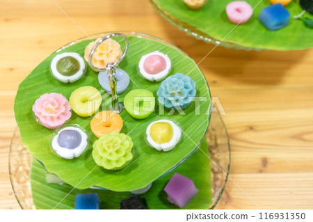 Varieties traditional colorful Thai desserts set; NamDokMai (steaming flour), PiekPoon (black custard), LeumKluen (coconut custard & steaming bean), KanomChan (layer pudding cake) Varieties traditional colorful Thai desserts set; NamDokMai (steaming flour), PiekPoon (black custard), LeumKluen (coconut custard & steaming bean), KanomChan (layer pudding cake) 116931350